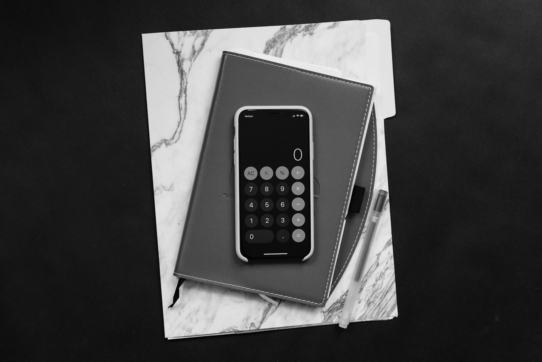 Defter üzerinde hesap makinesi, siyah-beyaz